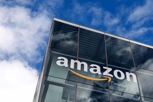 Amazon corporate logo and AI code on screens representing the acquisition talks.