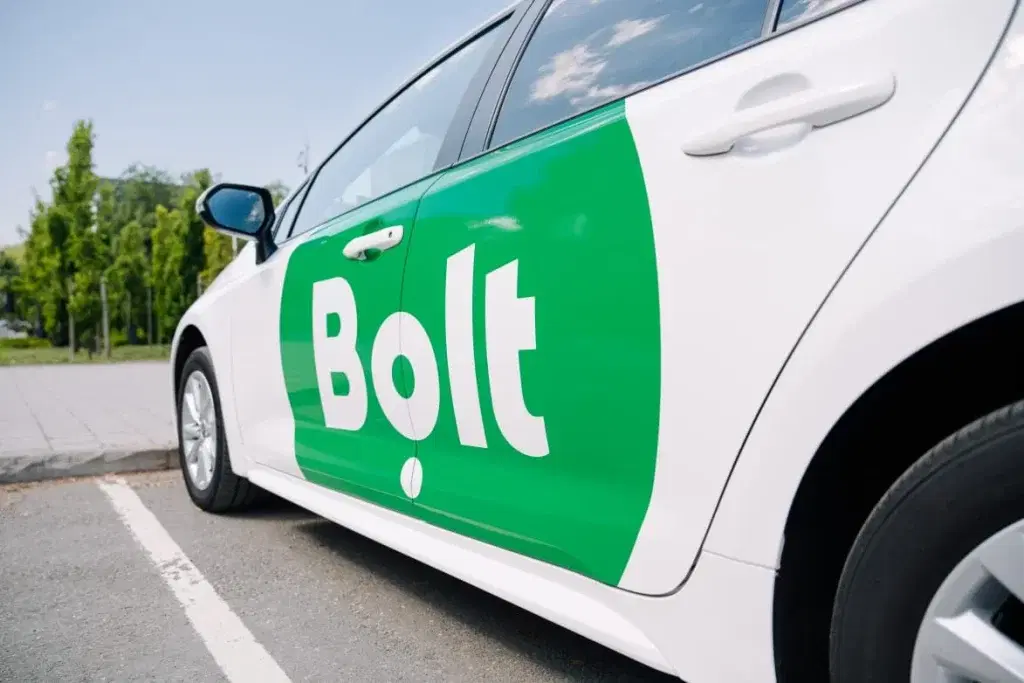 A smartphone showing a ride-hailing app inside a vehicle.