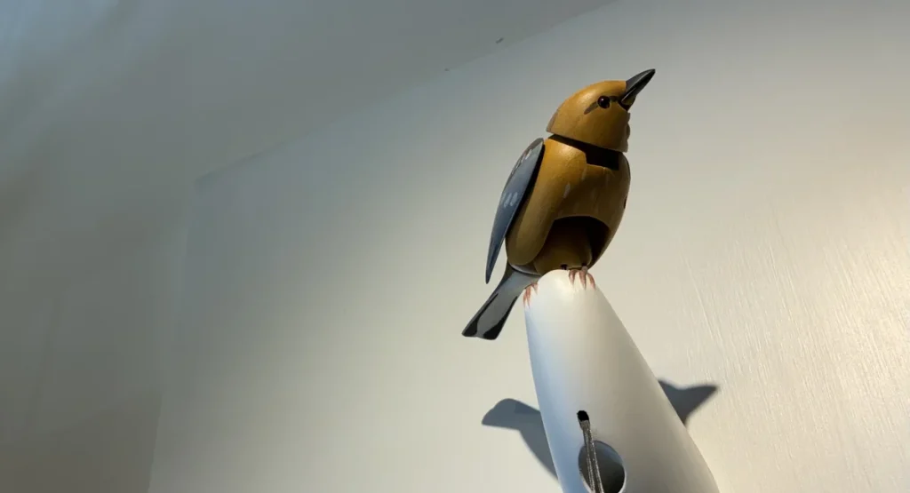 Molly the animatronic singing bird mounted on a wall inside Art of Play in Brooklyn